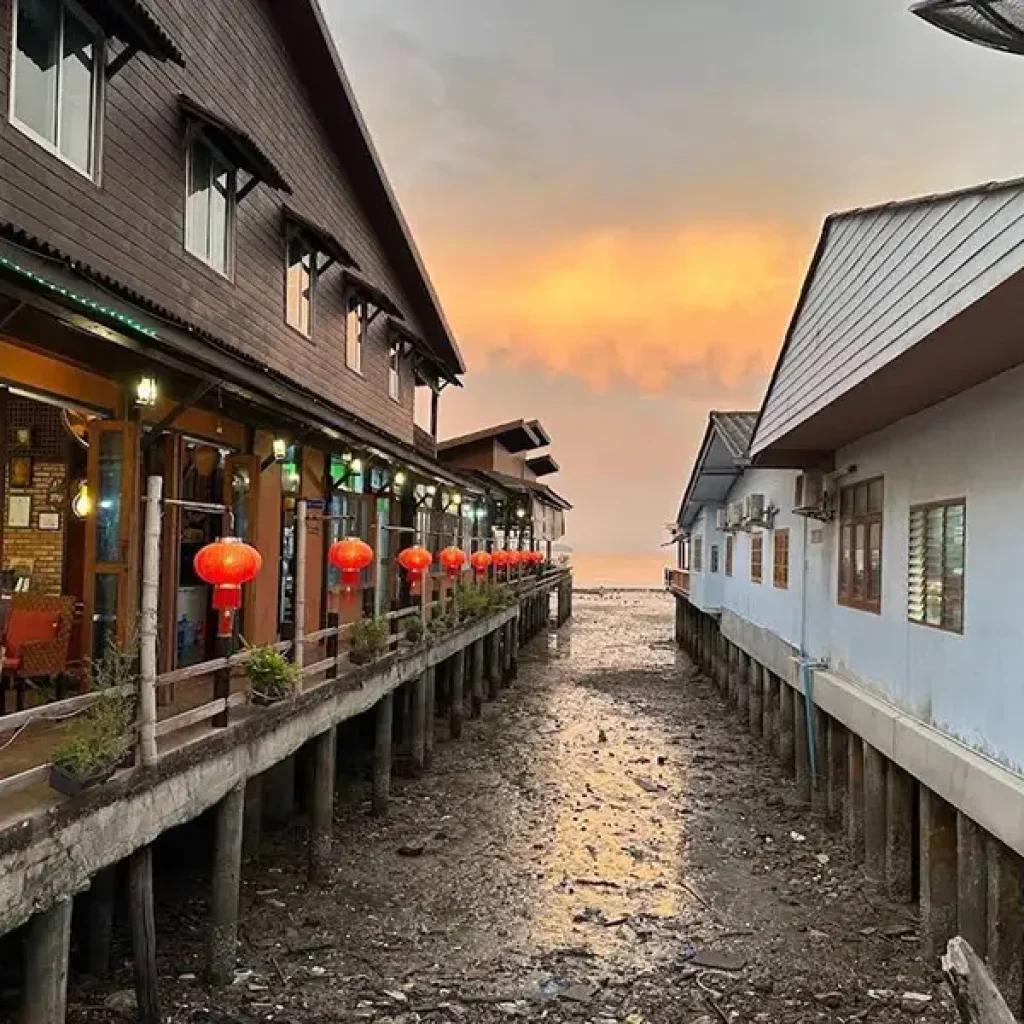Koh Lanta Old Town waterfront wooden houses on stilts at sunset with red lanterns