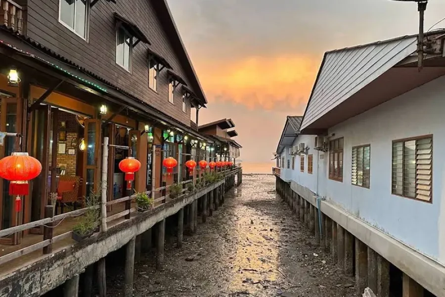 Koh Lanta Old Town waterfront wooden houses on stilts at sunset with red lanterns