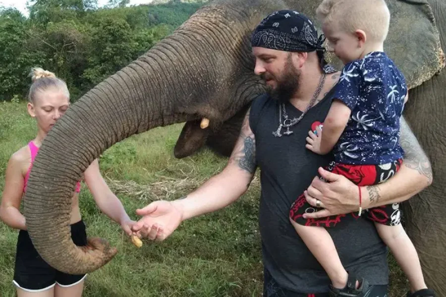 Family feeding elephant with trunk in Koh Lanta elephant camp ethical camp