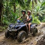 ATV Adventure Koh Lanta Couple riding blue Yamaha ATV through muddy jungle trail in Koh Lanta